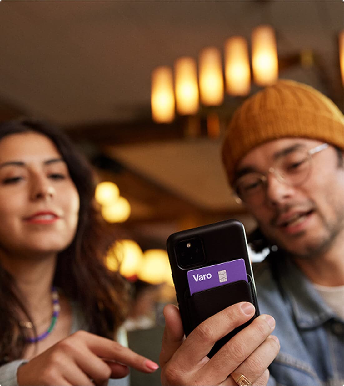 friends in a diner sending money to one another using varo